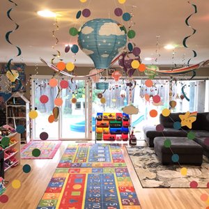 Bright indoor playroom with learning rugs and toy shelves