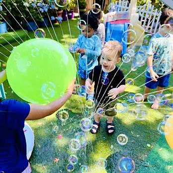 Child laughing surrounded by bubbles