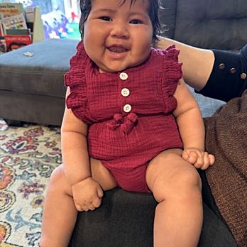 Smiling baby in a maroon romper