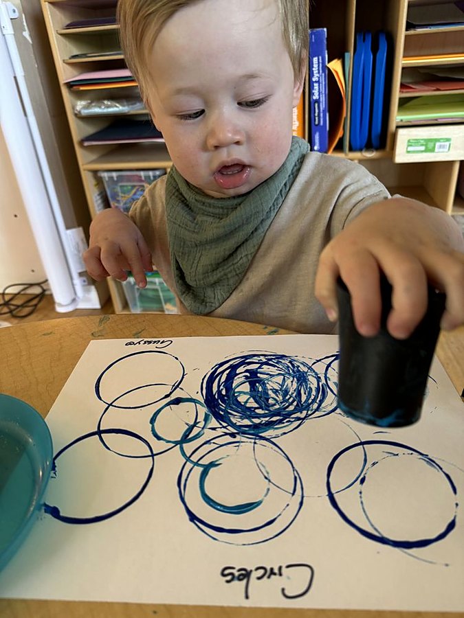 Toddler doing a circle-painting art activity