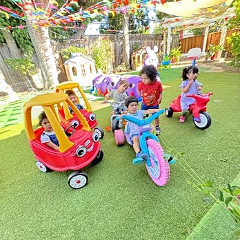 Kids riding trikes and cozy coupes in the play yard
